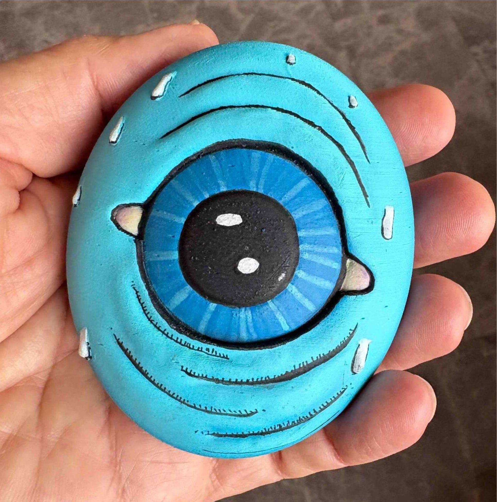 Hand-painted Egg-O sculpture with a large blue eye